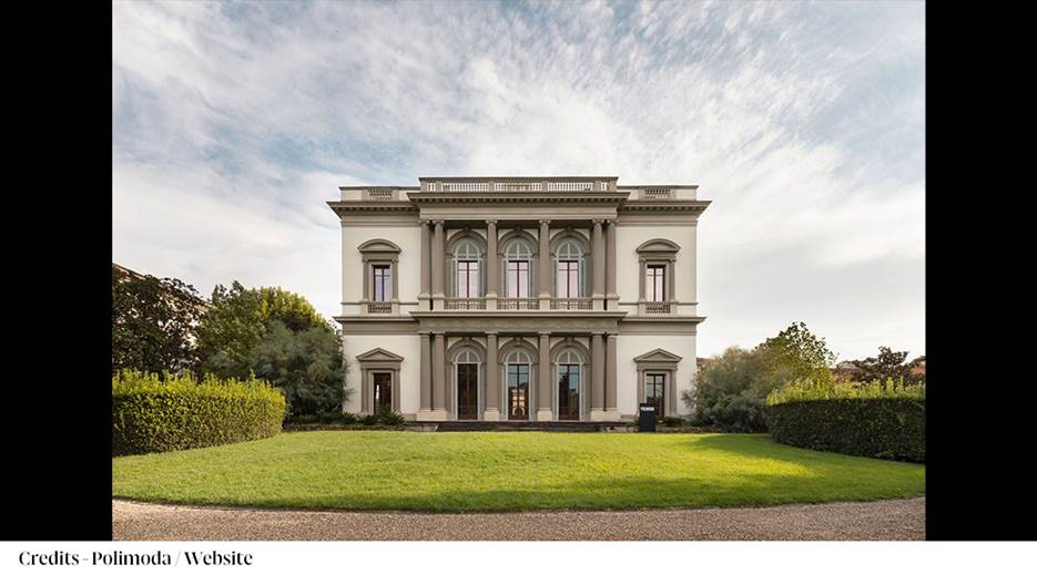 A large white building with a lawn and trees

Description automatically generated